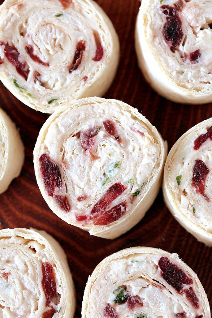 Cranberry Turkey Tortilla Roll Ups – these quick and easy, bite size tortilla roll ups, filled with cranberries, turkey, cream cheese, sour cream, grated white cheddar cheese, parsley and spices are perfect appetizer for holidays and parties. 