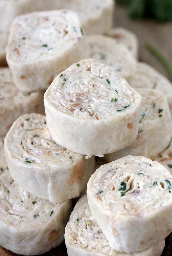 Creamy Chicken Tortilla Pinwheels – these delicious, quick and easy appetizer bites are actually tortillas filled with cream cheese, sour cream, mozzarella, chicken, onion and cilantro, seasoned with black pepper and garlic, then rolled up and sliced