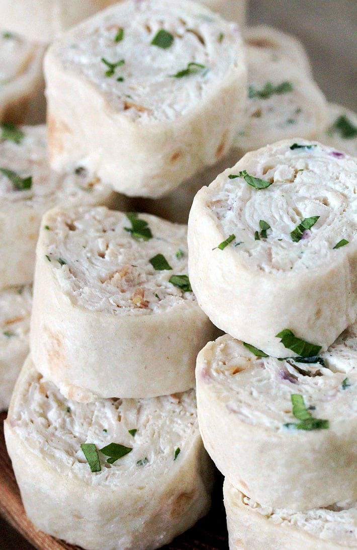 Creamy Chicken Tortilla Pinwheels – these delicious, quick and easy appetizer bites are actually tortillas filled with cream cheese, sour cream, mozzarella, chicken, onion and cilantro, seasoned with black pepper and garlic, then rolled up and sliced.