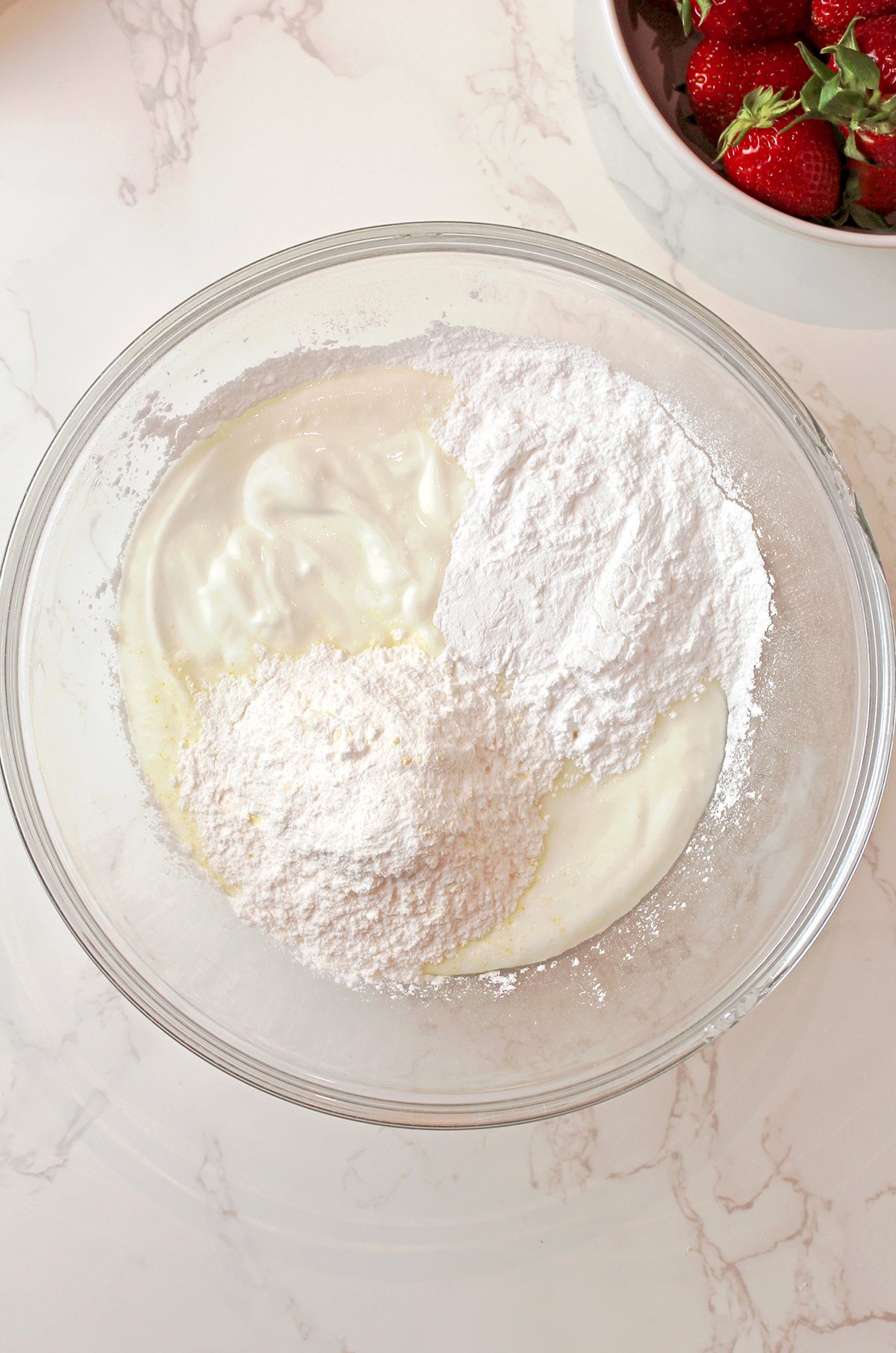 Mixing Greek yogurt, vanilla pudding mix, and powdered sugar for creamy fluff salad base.