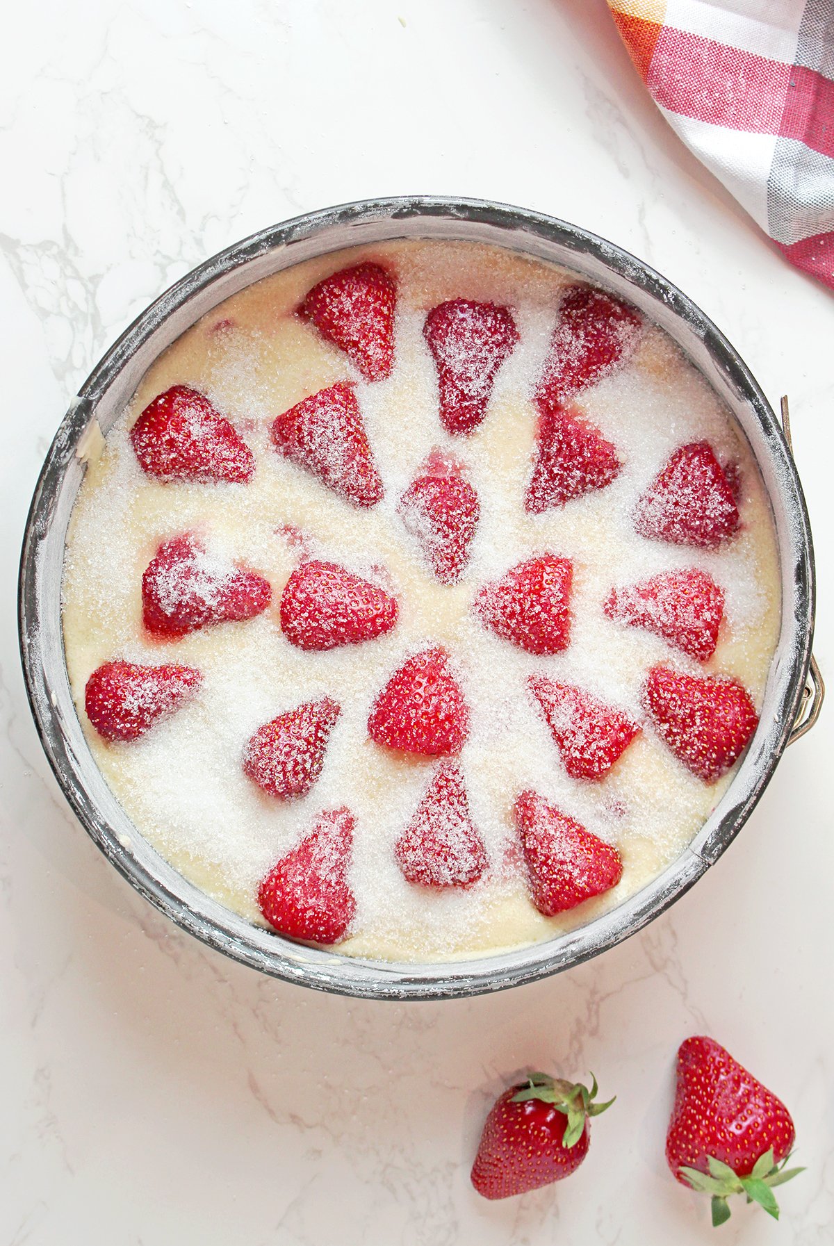 Step 6: Top with Strawberries
Pour the batter into the pan and top with remaining strawberries.