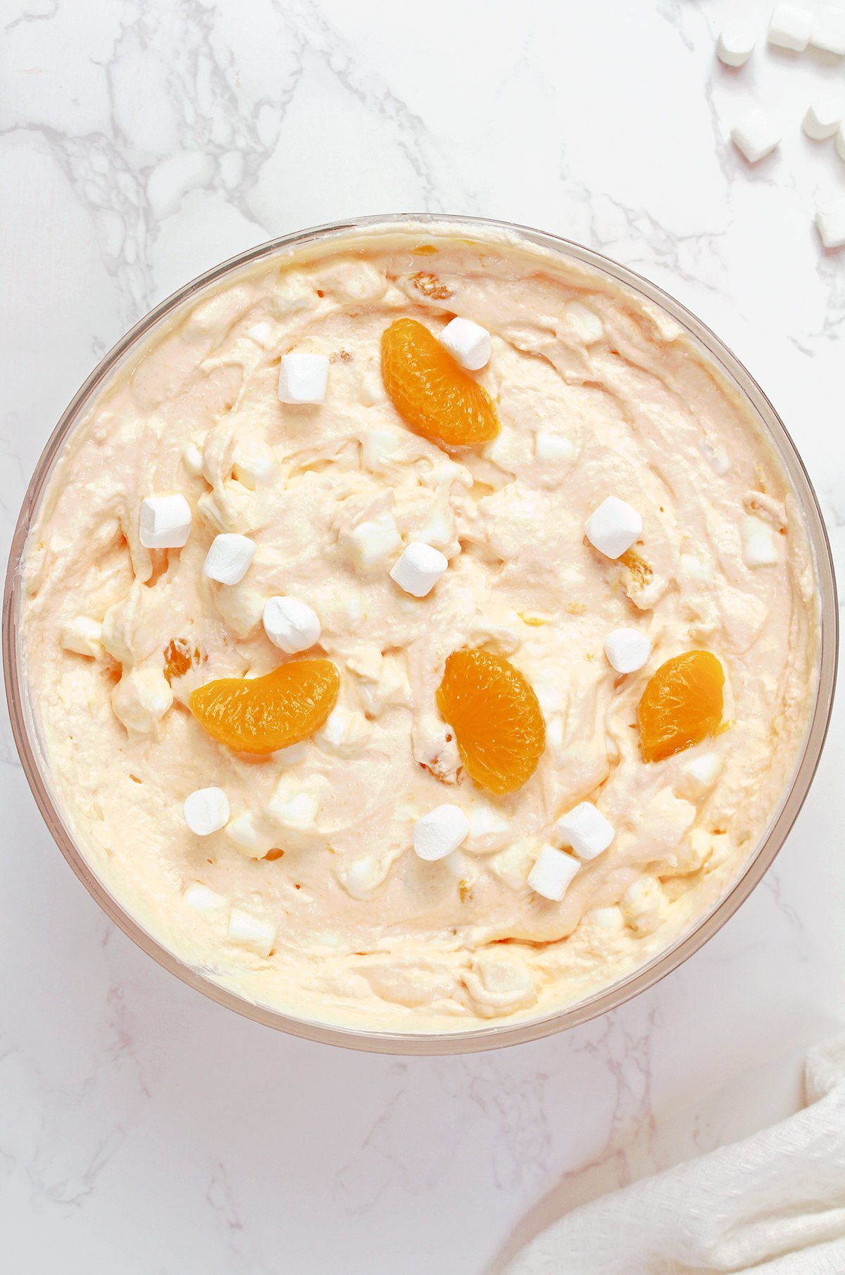 Creamsicle Orange Cheesecake Fluff Salad served in a bowl with mandarin oranges and mini marshmallows.