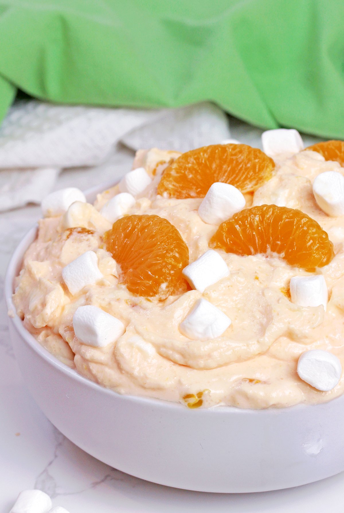 Creamsicle Orange Cheesecake Fluff Salad served in a bowl with mandarin oranges and mini marshmallows.