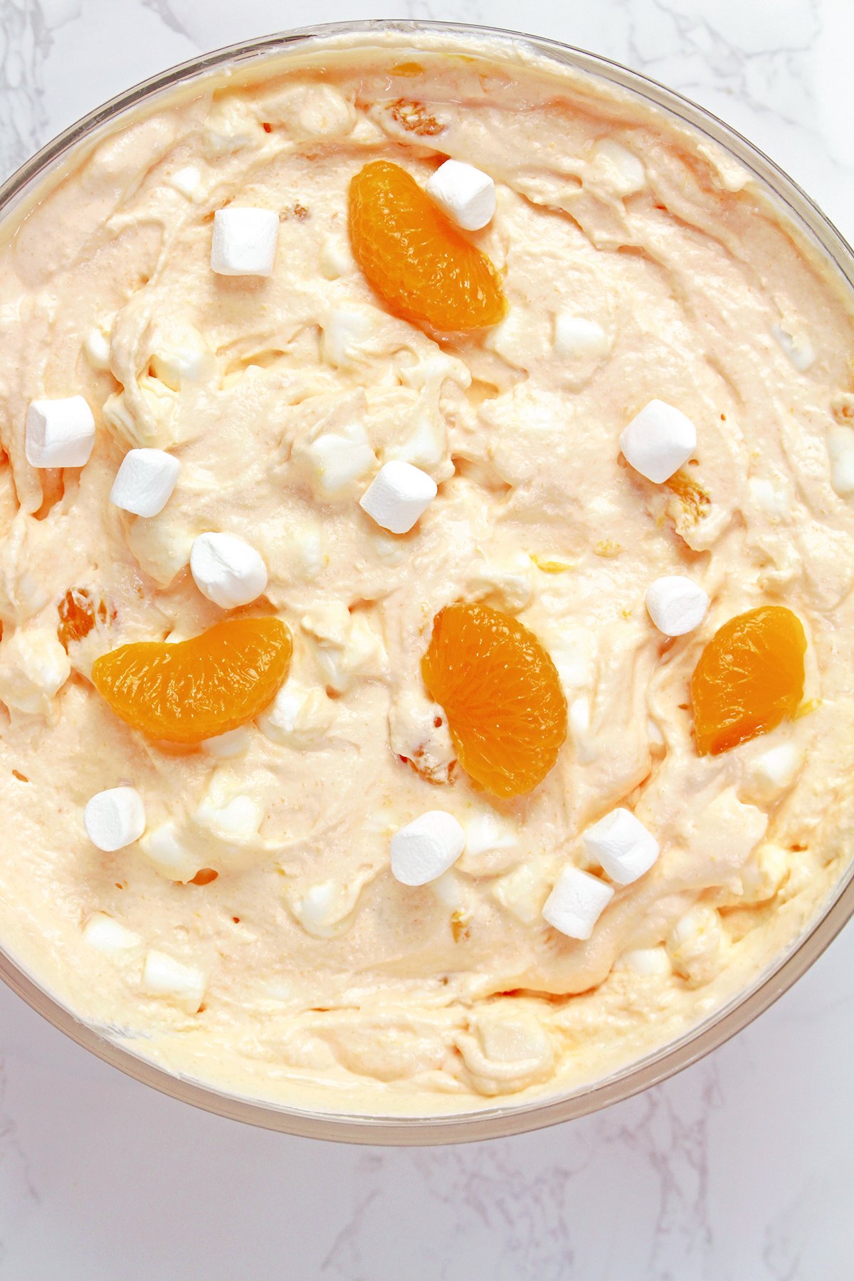 Creamsicle Orange Cheesecake Fluff Salad served in a bowl with mandarin oranges and mini marshmallows.