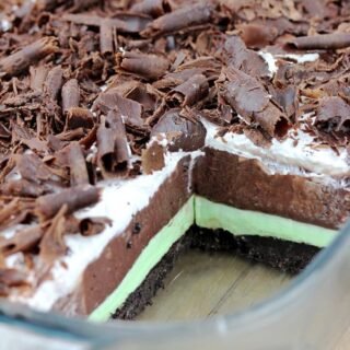 Mint Chocolate Lasagna easy no-bake dessert with layers of Oreo crust, Mint cream cheese, Chocolate pudding, Whipping Cream and Chocolate Curls on top.