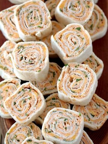 Taco Tortilla Roll Ups this quick and easy party appetizer filled with cream cheese, sour cream, chicken, cheddar cheese, taco seasoning, taco sauce and parsley is perfect for every holiday or a party.
