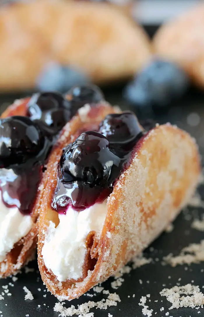 Blueberry Cheesecake Tacos – this is a recipe for very tasty dessert tacos. If you ask me, crunchy tortilla shells, filled with cheesecake filling and topped with homemade blueberry sauce make a perfect dessert.