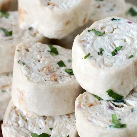 Creamy Chicken Tortilla Pinwheels – these delicious, quick and easy appetizer bites are actually tortillas filled with cream cheese, sour cream, mozzarella, chicken, onion and cilantro, seasoned with black pepper and garlic, then rolled up and sliced.