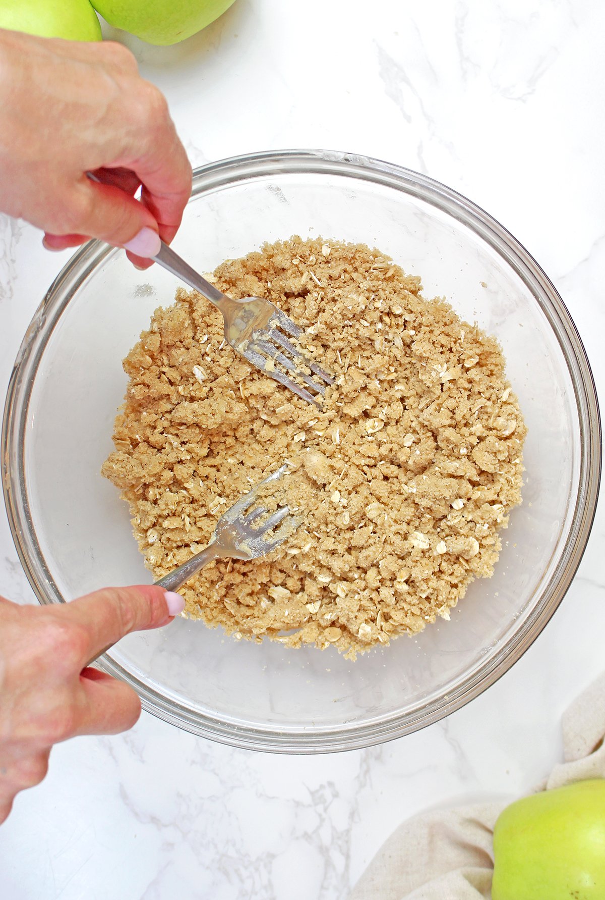 Mixing the oat crumble topping with flour, oats, brown sugar, cinnamon, and butter.