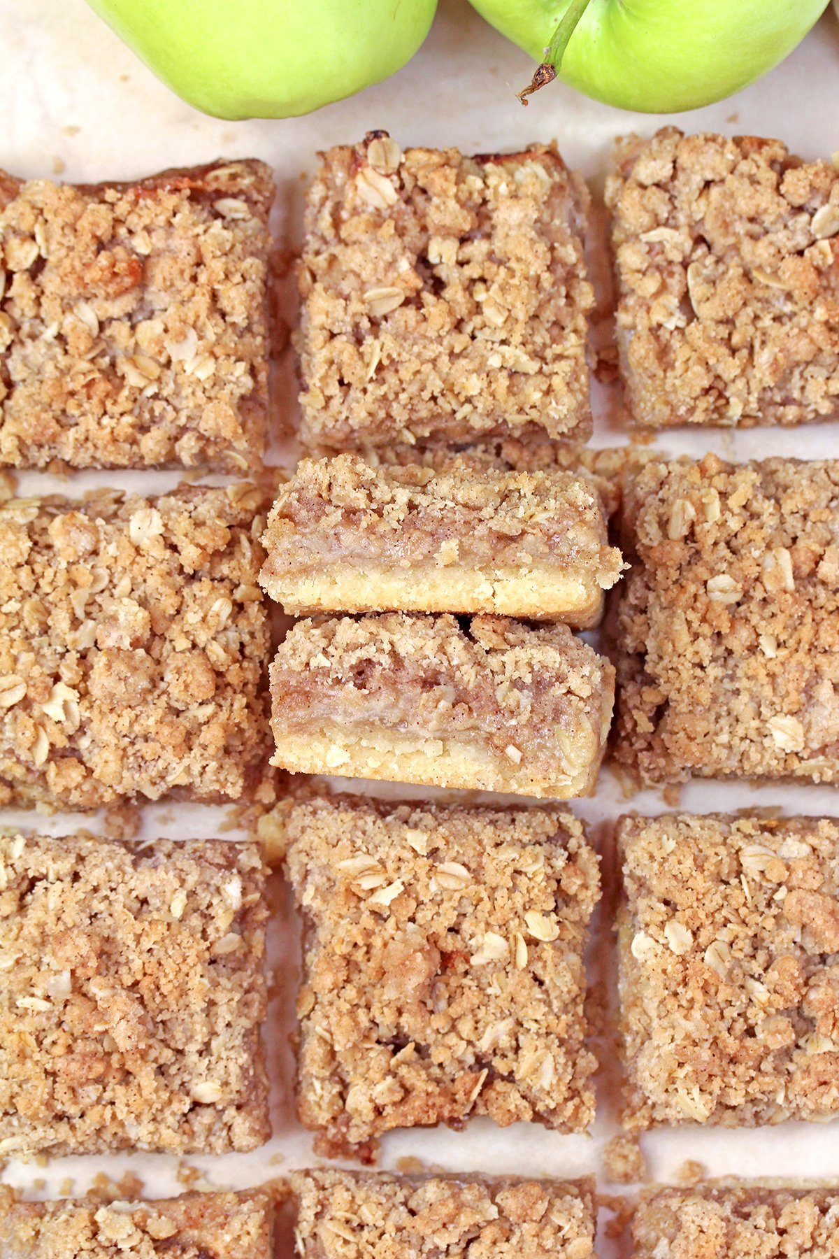 Apple Crisp Bars cut into squares on parchment paper, photographed from above.