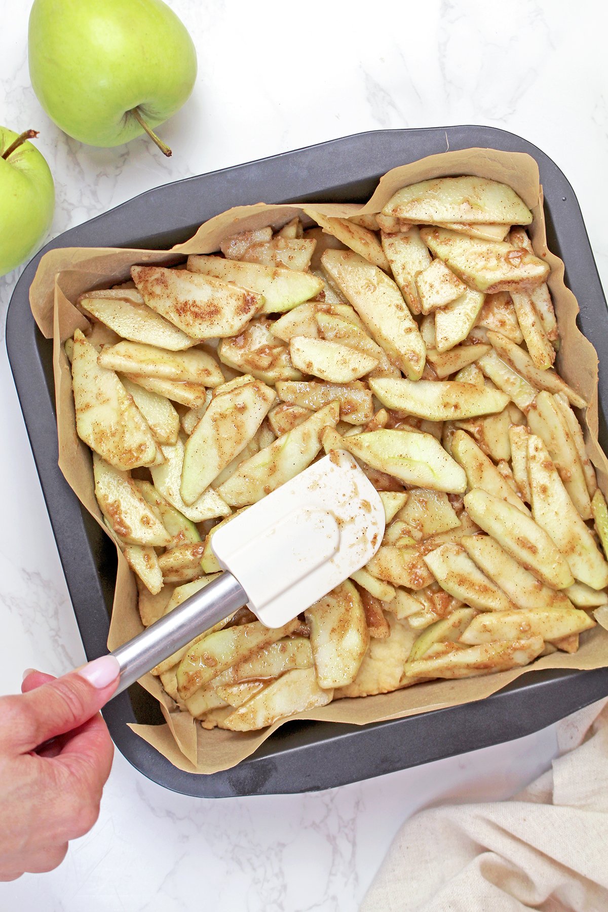 Spreading the apple filling evenly over the baked shortbread crust.