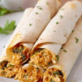 Cream Cheese Chicken Flautas – crunchy tortillas, juicy chicken and melted cheese make an incredible combination. These flautas are made of shredded cooked chicken, cream cheese, cheddar cheese, sour cream, spinach, salsa and different spices, all rolled up in tortillas, then baked or fried and finally served with salsa, guacamole sauce or sour cream