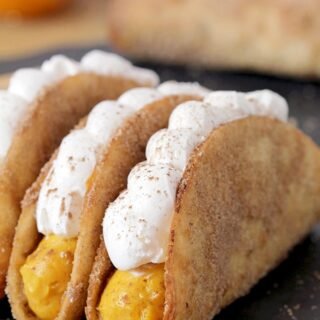 Pumpkin Pie Tacos - these mini crunchy cinnamon and sugar tortilla shells, filled with pumpkin filling and topped with whipped topping are an ultimate fall dessert. Prepared for Halloween or Thanksgiving Day, they will be a hit!