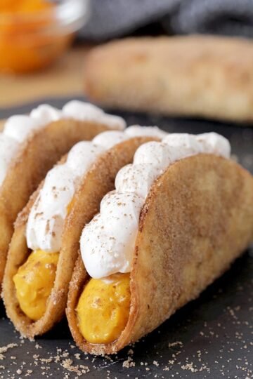 Pumpkin Pie Tacos – these mini crunchy cinnamon and sugar tortilla shells, filled with pumpkin filling and topped with whipped topping are an ultimate fall dessert. Prepared for Halloween or Thanksgiving Day, they will be a hit!