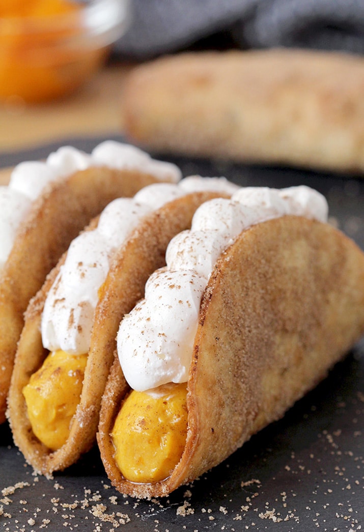 Pumpkin Pie Tacos – these mini crunchy cinnamon and sugar tortilla shells, filled with pumpkin filling and topped with whipped topping are an ultimate fall dessert. Prepared for Halloween or Thanksgiving Day, they will be a hit!