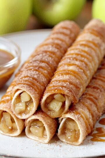 Caramel Apple Pie Taquitos – tortillas filled with apple pie filling, rolled in sugar and cinnamon, oven baked and drizzled with caramel sauce are real fall dessert. This quick and easy recipe will be a hit this fall. Caramel Apple Pie Taquitos can be served for breakfast, snack or a dessert.