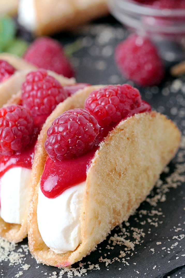 Raspberry Cheesecake Tacos – crunchy tortilla shells, creamy cheesecake filling, topped with raspberry sauce and fresh raspberries on top make this amazing dessert. These incredible bites are perfect for holidays, parties and other events. They are so quick and easy to make and they will quickly disappear from your dessert plate, so be ready to make them over and over again.