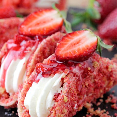 Strawberry Crunch Cheesecake Tacos – crunchy tortilla shell coated in white chocolate and strawberry crunch, creamy cheesecake filling, topped with fresh strawberries and strawberry syrup is a true delight!