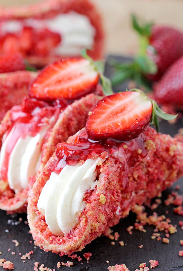 Strawberry Crunch Cheesecake Tacos – crunchy tortilla shell coated in white chocolate and strawberry crunch, creamy cheesecake filling, topped with fresh strawberries and strawberry syrup is a true delight!