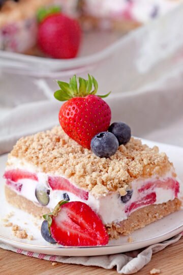 Easy Berry Dream Dessert – this quick and easy no bake dessert with buttery graham cracker crust, creamy filling made of cream cheese, butter, whipped cream, fresh blueberries and strawberries, topped with graham crackers crumbs is the right choice for the 4th of July, as well as for the entire spring and summer season. This Berry Dream Dessert can also be a perfect potluck dessert!