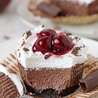 Black Forest Mini Cheesecakes – this easy no bake recipe with Oreo crust, decadent smooth chocolate cheesecake, juicy cherries on a soft, fluffy whipped cream cloud is a dessert you simply have to try.