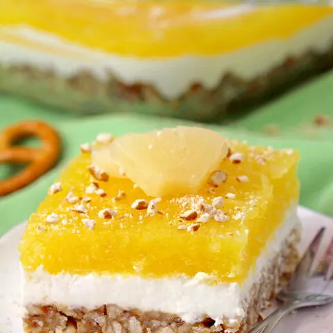 Pineapple Pretzel Salad - with crunchy pretzel crust, creamy filling made of cream cheese and cool whip, with refreshing pineapple layer on top is easy to prepare and so tasty. The combination of sweet and salty, crunchy and creamy and tropical taste best describe this unique salad, perfect for potlucks or holidays.