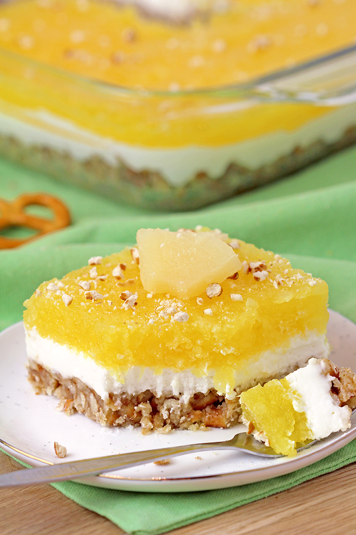 Pineapple Pretzel Salad - with crunchy pretzel crust, creamy filling made of cream cheese and cool whip, with refreshing pineapple layer on top is easy to prepare and so tasty. The combination of sweet and salty, crunchy and creamy and tropical taste best describe this unique salad, perfect for potlucks or holidays.