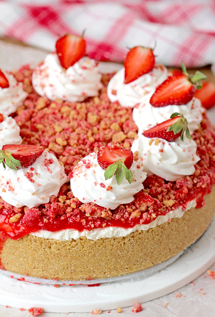 Strawberry Crunch Cheesecake - prepare this easy, no-bake recipe for BBQs, holidays or parties and it’ll  be a huge hit!!! Graham cracker crust, creamy, smooth cheesecake filling, strawberry sauce and  strawberry crunch topping with whipped topping and fresh strawberries on top make this delicious dessert.