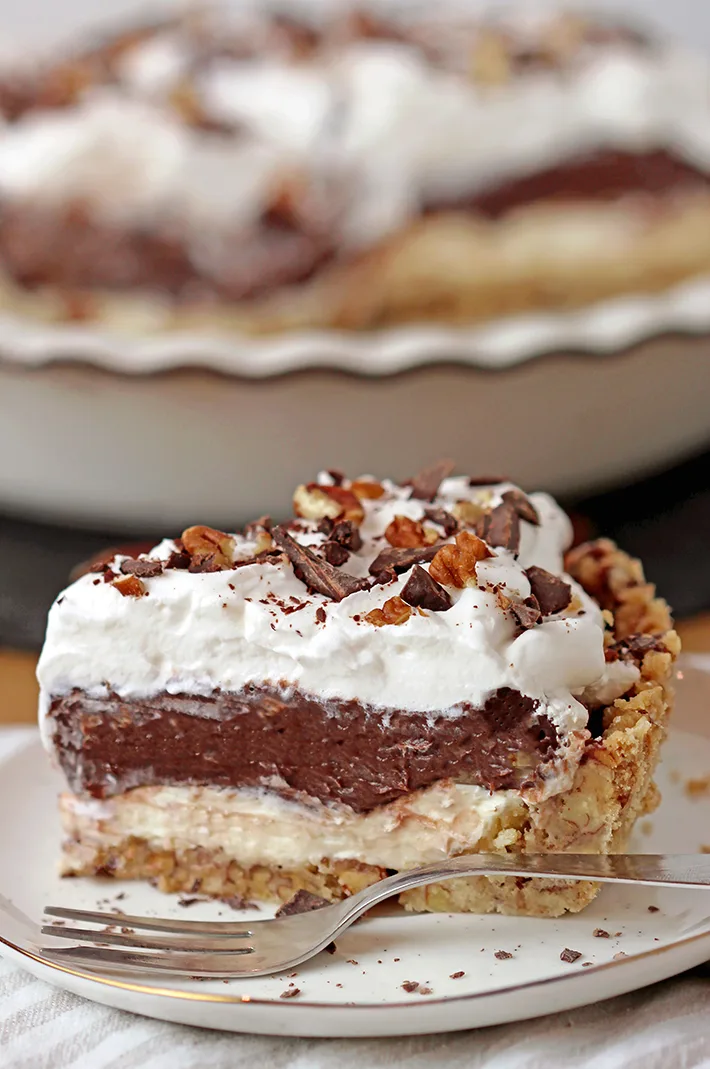 Arkansas Possum Pie - this easy southern pie with 4 layers is perfect for upcoming holidays. Prepare it for Thanksgiving and you’ll be pleasantly surprised.. Buttery pecan shortbread crust, cream cheese layer, decadent chocolate pudding layer topped with fluffy whipped cream, some more chocolate and pecans, in one word - perfection!