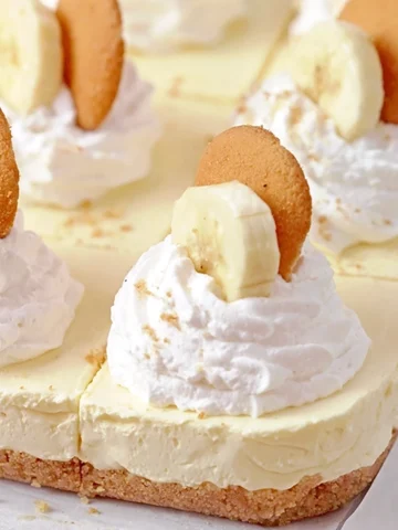 Banana Pudding Cheesecake Bars – with a Nilla wafer crust, a creamy cheese and pudding filling, this dessert is the perfect fusion of two desserts: banana pudding and cheesecake.