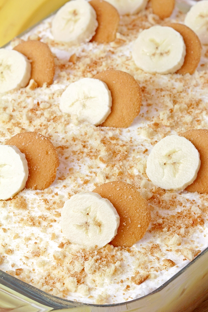 Banana Pudding Poke Cake – quick and easy, moist and soft, made with yellow cake mix, filled with banana pudding, topped with whipped topping, banana slices, and crushed Nilla Wafers. Try this simple and creamy Banana Pudding Poke Cake – a perfect combination of cake, banana pudding, and whipped cream!