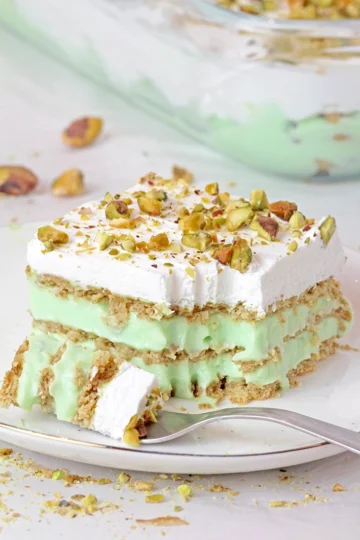 This Pistachio Icebox Cake is a super quick and easy recipe made with layers of graham crackers, instant pistachio pudding filling, and whipped topping in between. It’s topped with whipped topping and chopped pistachios. Made with just 5 simple ingredients in only 10 minutes, it’s perfect when you don’t have much time but want a delicious treat!