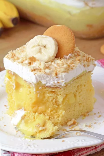 Banana Pudding Poke Cake – quick and easy, moist and soft, made with yellow cake mix, filled with banana pudding, topped with whipped topping, banana slices, and crushed Nilla Wafers. Try this simple and creamy Banana Pudding Poke Cake – a perfect combination of cake, banana pudding, and whipped cream!