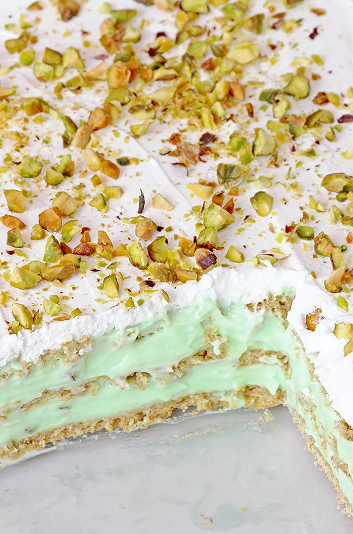 This Pistachio Icebox Cake is a super quick and easy recipe made with layers of graham crackers, instant pistachio pudding filling, and whipped topping in between. It’s topped with whipped topping and chopped pistachios. Made with just 5 simple ingredients in only 10 minutes, it’s perfect when you don’t have much time but want a delicious treat!