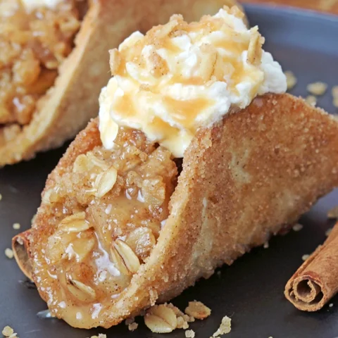 These Apple Crisp Tacos are the ultimate fall dessert, made with crispy cinnamon - sugar tortilla shells filled with apple crisp, topped with whipped topping or ice cream and drizzled with caramel sauce. They are perfect for gatherings, parties, picnics or even holidays.