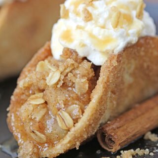These Apple Crisp Tacos are the ultimate fall dessert, made with crispy cinnamon - sugar tortilla shells filled with apple crisp, topped with whipped topping or ice cream and drizzled with caramel sauce. They are perfect for gatherings, parties, picnics or even holidays.