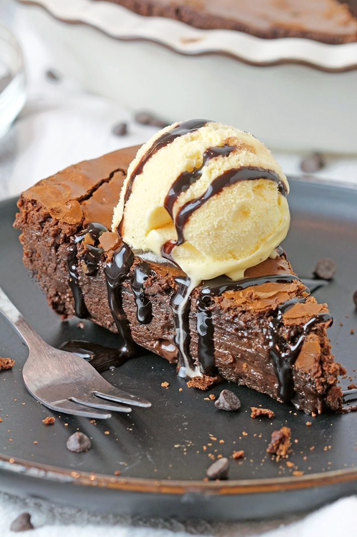 Gooey Chocolate Brownie Pie is one of the most delicious and easiest pies I have ever made. Gooey texture and crackly top – simply perfection! It is a family favorite so we often prepare it and always enjoy its rich taste. It is typically served with whipped topping or a scoop of vanilla ice cream and drizzled with hot fudge sauce.