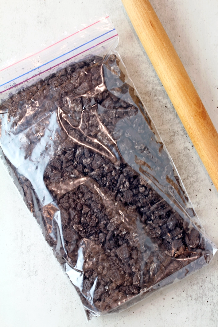 Crush the Oreo cookies. You can do this in two ways:  Place the cookies in a large zip-top bag, seal it, and crush them with a rolling pin,or place them in a food processor and pulse until they’re broken down.