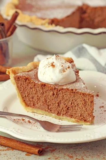 The Best Cinnamon Pie dusted with powdered sugar and topped with whipped cream