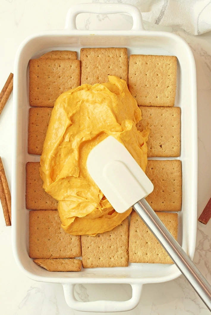 Line the bottom of a 9x13-inch dish with a layer of graham crackers. Spread half of the pumpkin filling over the top.