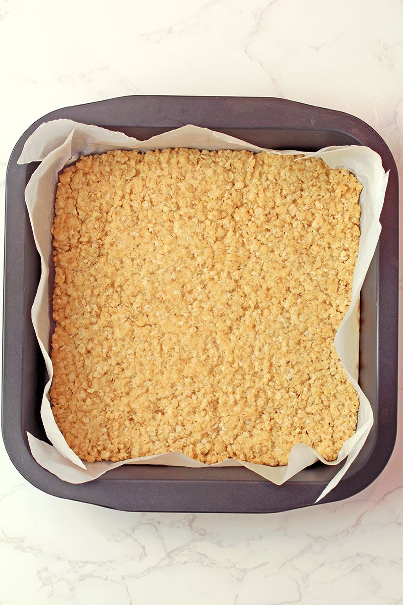 Step 2 - Bake the crust base
Press most of the mixture into a lined baking pan and bake until lightly golden, while reserving 1 cup of the mixture for the topping.