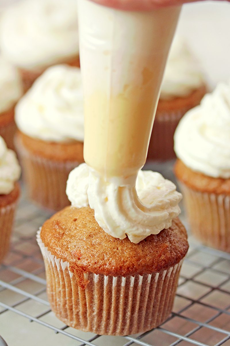 Moist carrot cupcakes with coconut pineapple cream cheese frosting, bakery-style, ready to serve.
