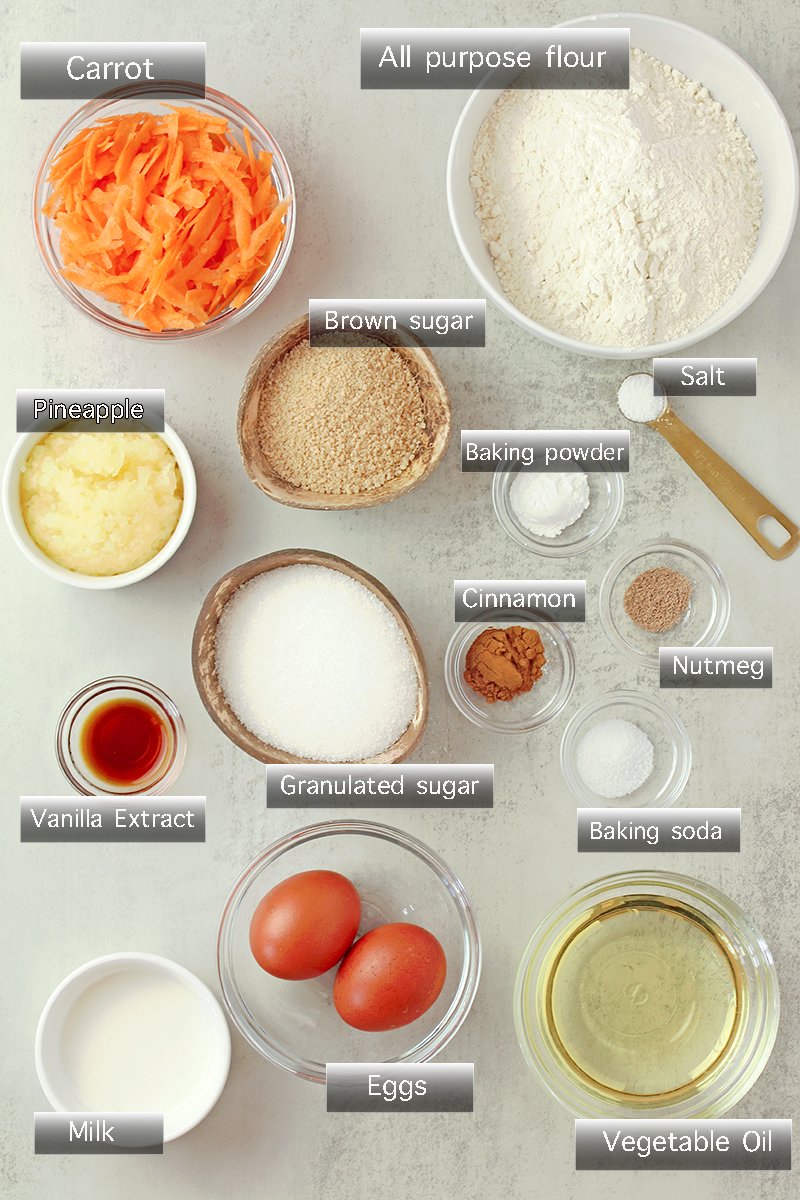 Ingredients for Carrot Pineapple Cupcakes including grated carrots, crushed pineapple, flour, eggs, sugars, vegetable oil, milk, cinnamon, nutmeg, and vanilla.