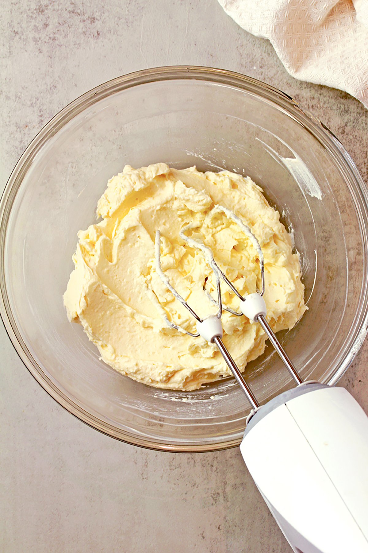 Butter and cream cheese being beaten until smooth.