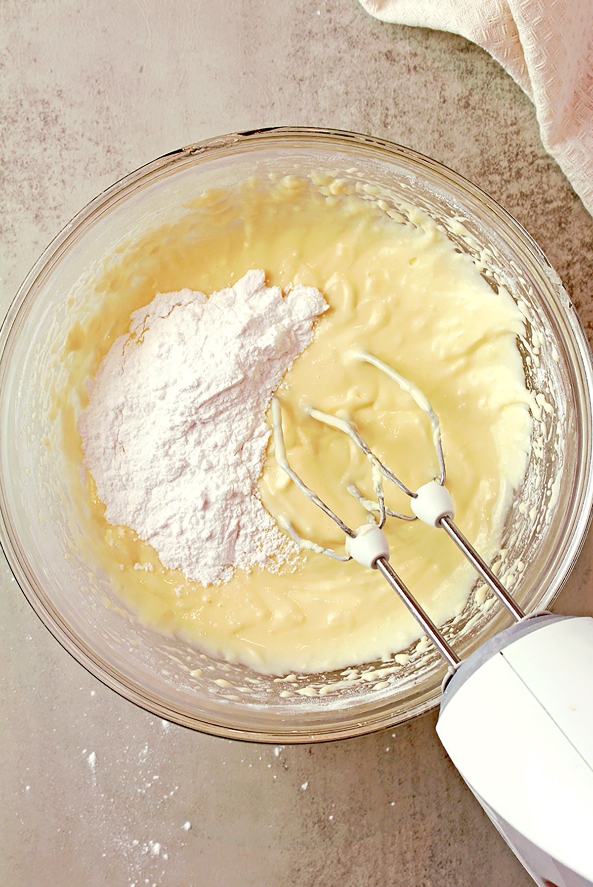 Powdered sugar being mixed into the frosting base.