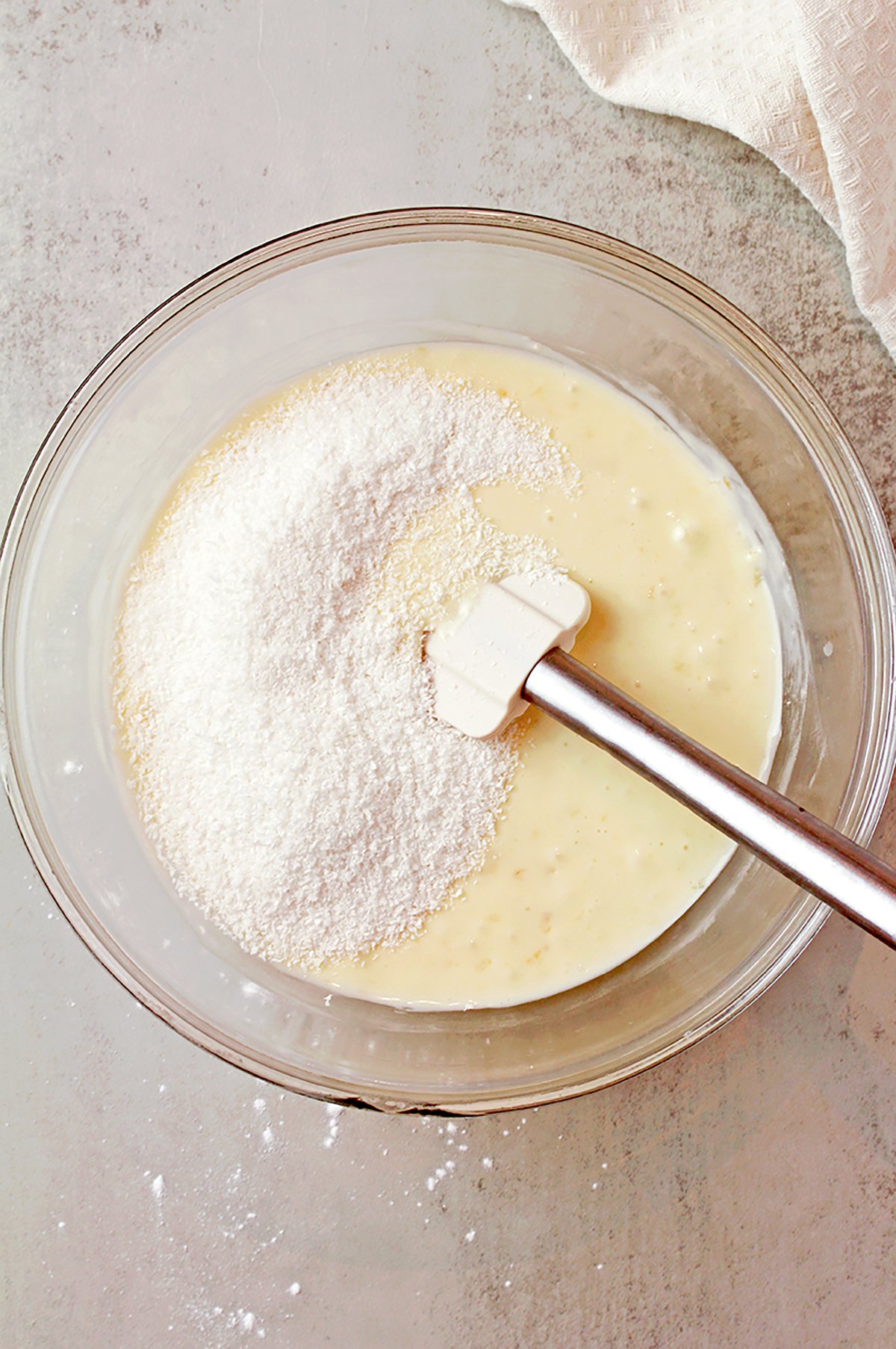 Desiccated coconut being folded into the frosting.