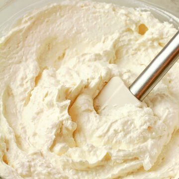 Coconut pineapple cream cheese frosting in a bowl, light and fluffy texture.