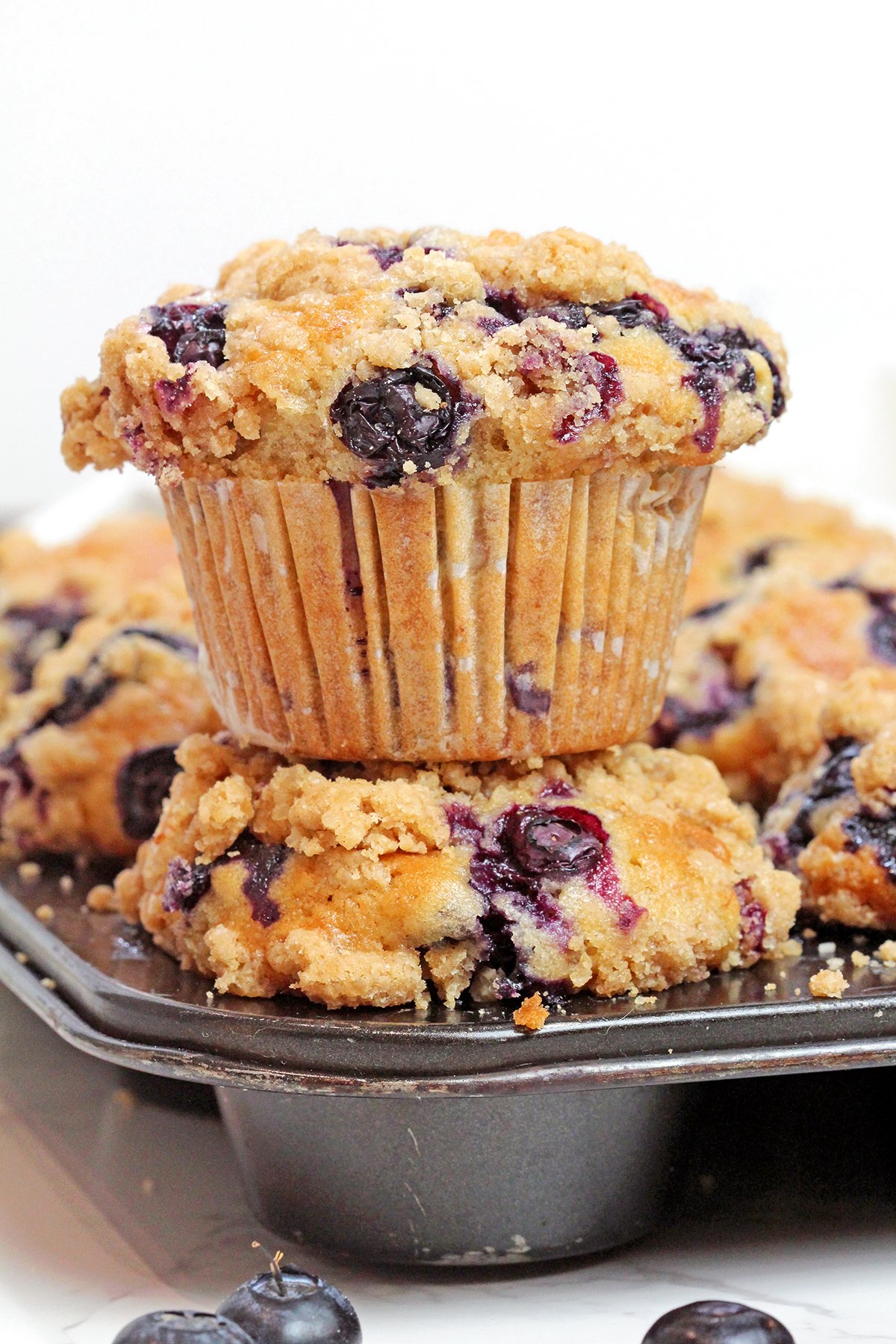 Made with ripe mashed bananas, juicy blueberries, crunchy walnuts, and topped with a buttery cinnamon streusel, these Banana Blueberry Muffins with Crumb Topping are soft, moist, and full of cozy flavor.