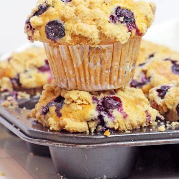 Made with ripe mashed bananas, juicy blueberries, crunchy walnuts, and topped with a buttery cinnamon streusel, these Banana Blueberry Muffins with Crumb Topping are soft, moist, and full of cozy flavor.