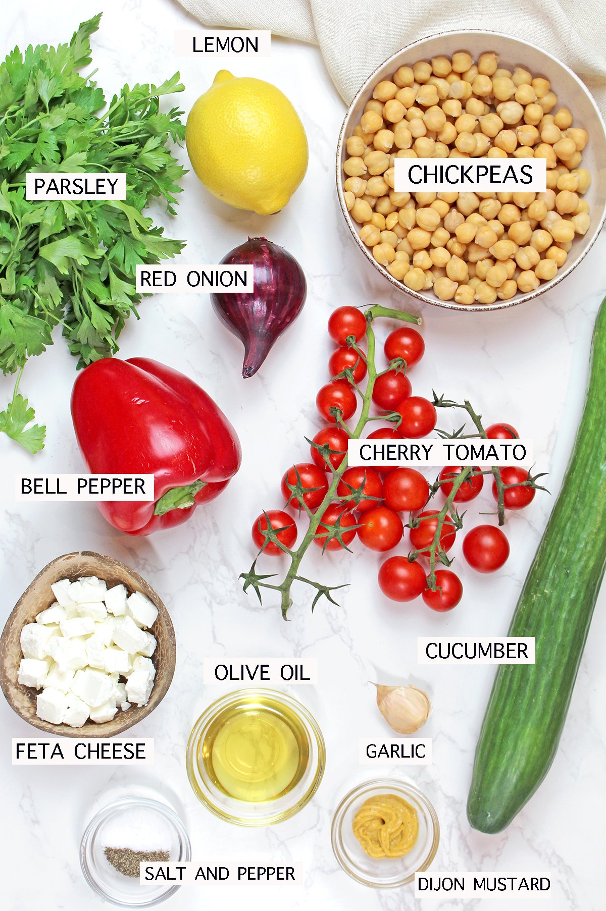 Mediterranean Chickpea Salad ingredients with chickpeas, feta, cherry tomatoes, cucumber, and fresh herbs.